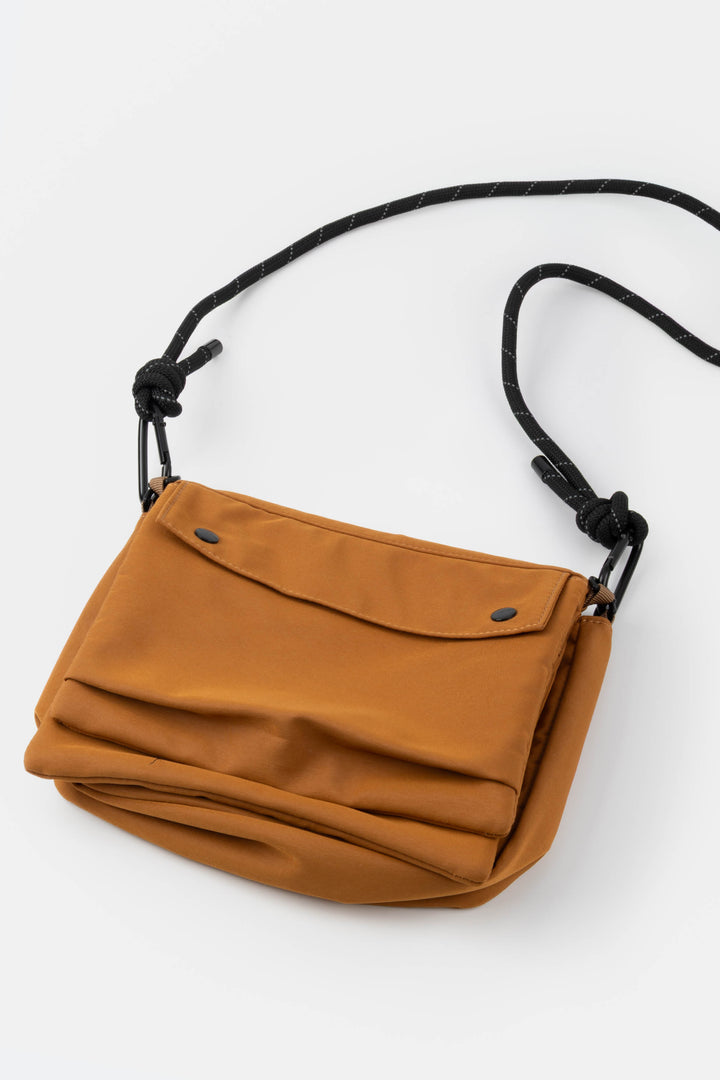 Orange utility bag with black strap on a white background