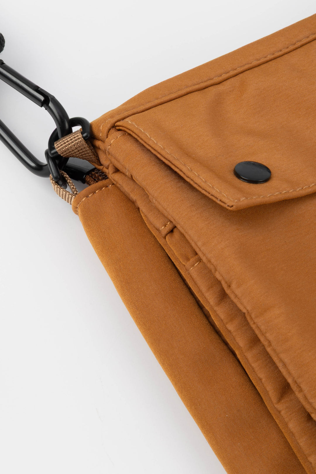Orange bag with a black button and strap on a white background
