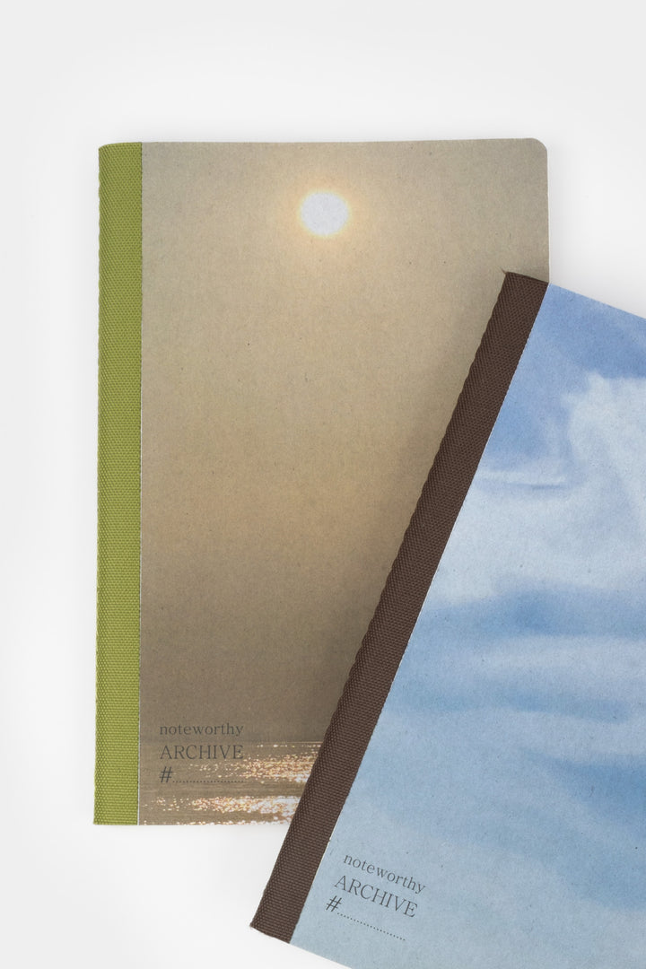 Two books a5 notebooks with covers featuring the sun and blue sky