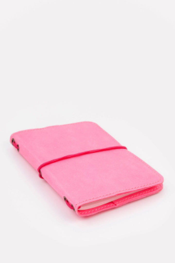 Pink passport size sketch journal on a white background