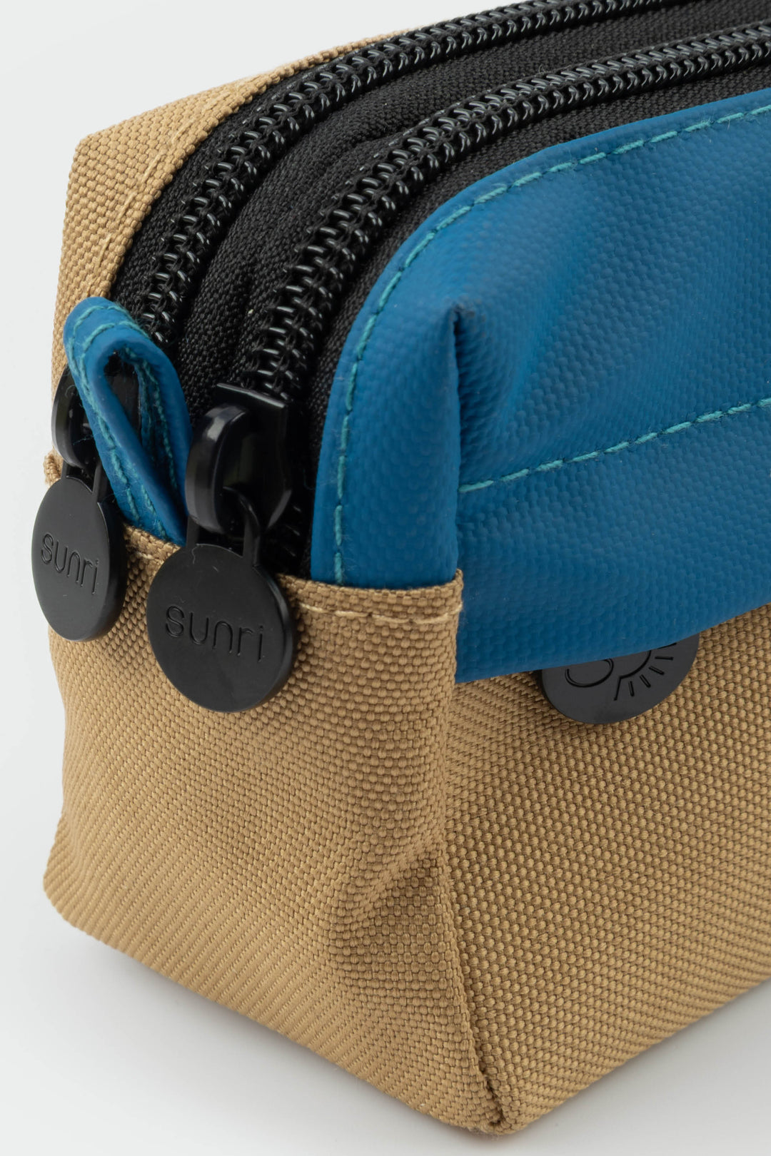 Close-up of a beige and blue pouch with zippers on a white background