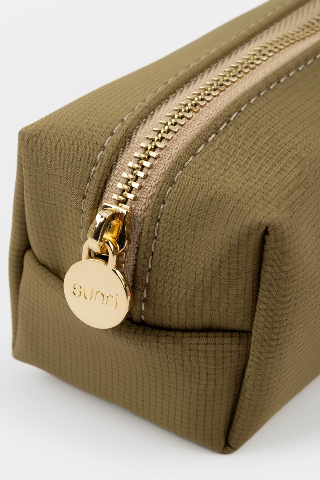 Brown toiletry bag with gold zipper and 'Sunri' logo on a white background