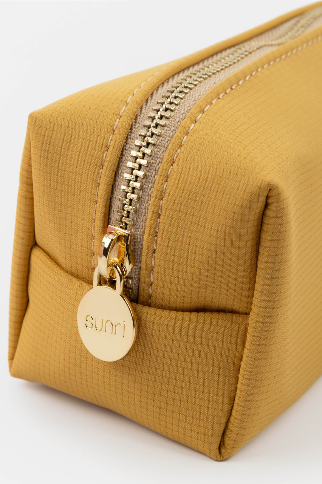 Mustard yellow pencil case with gold zipper and 'Sunri' tag on a white background