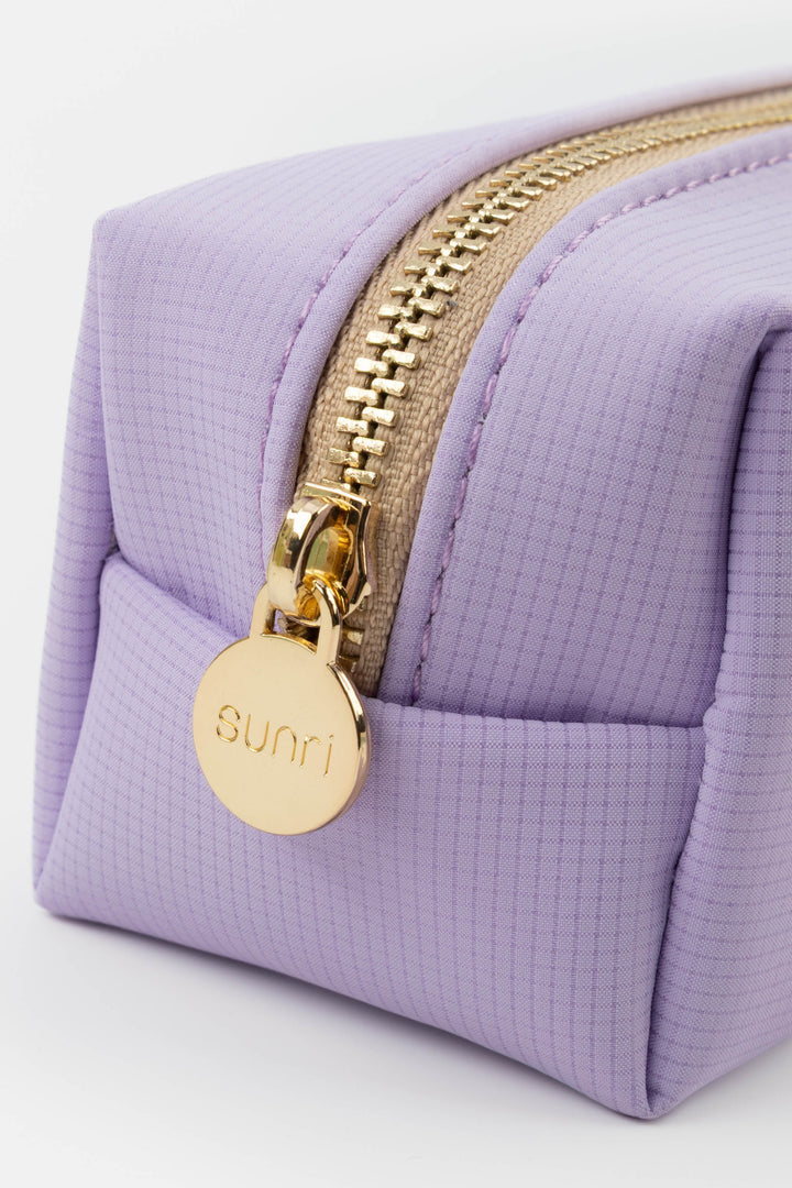 Purple pencil case with gold zipper and 'Sunri' tag on a white background