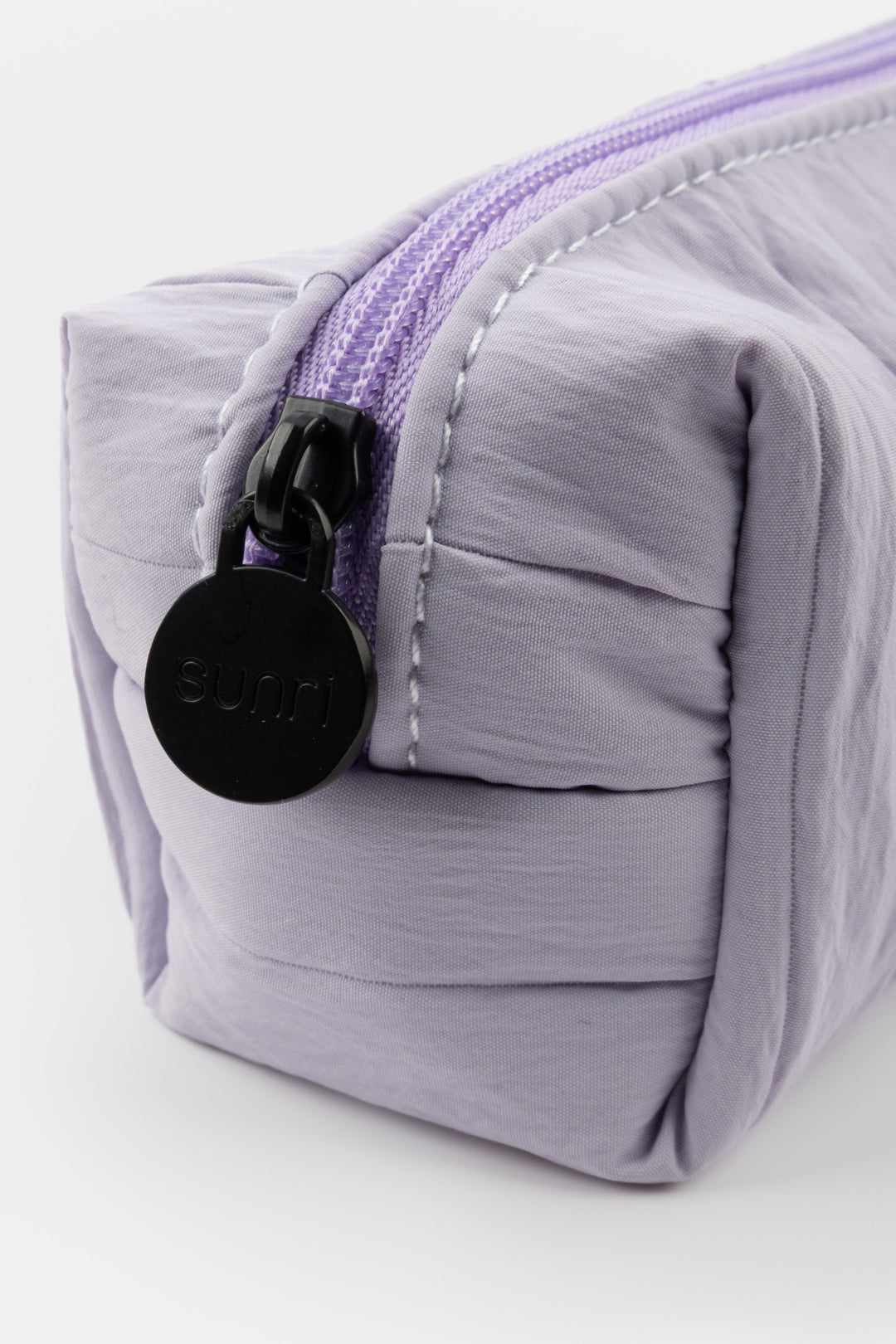 Purple pleated pouch with a black zipper and visible brand logo on a white background