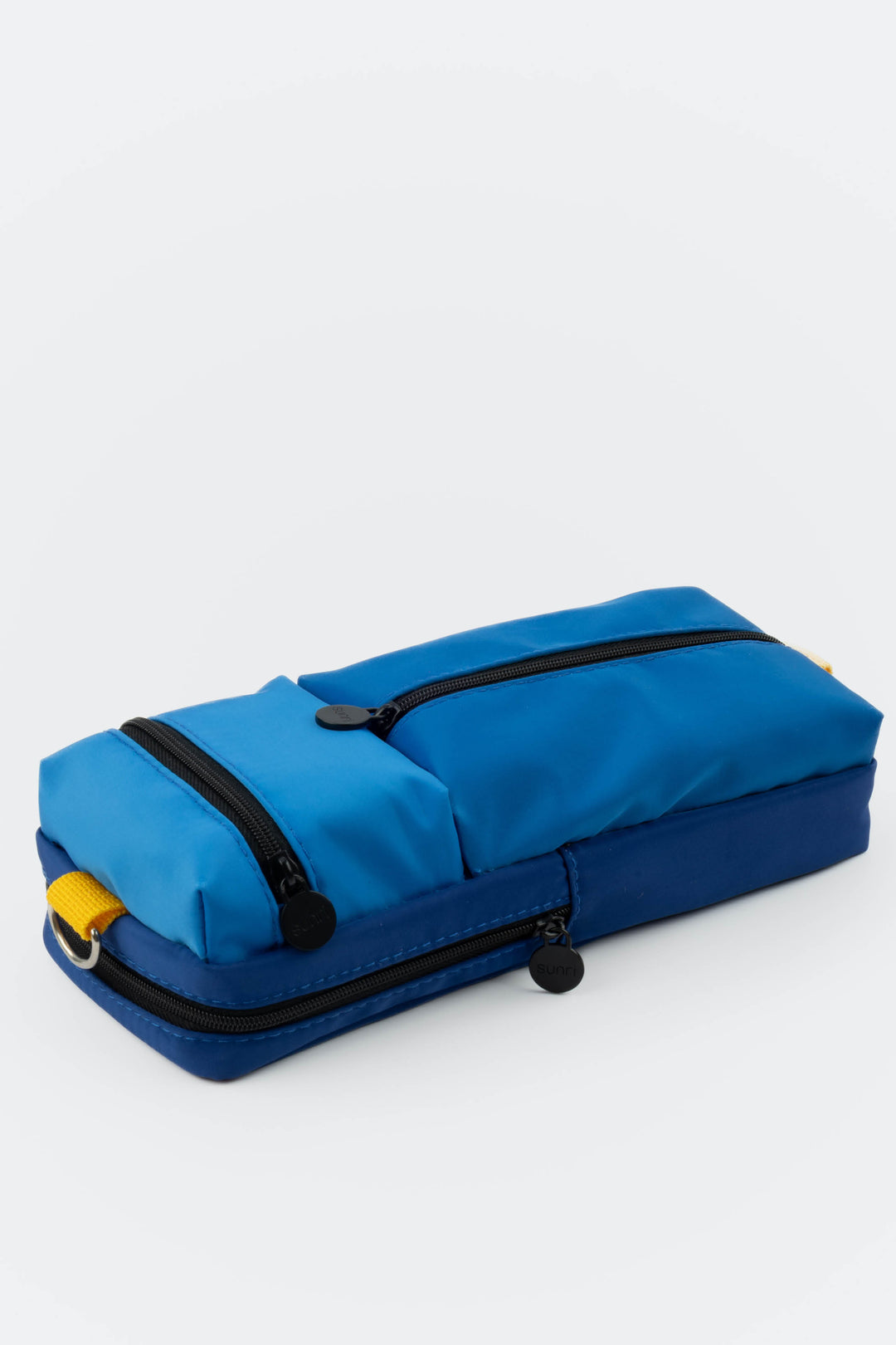 Blue and navy pencil case with black zippers on a white background