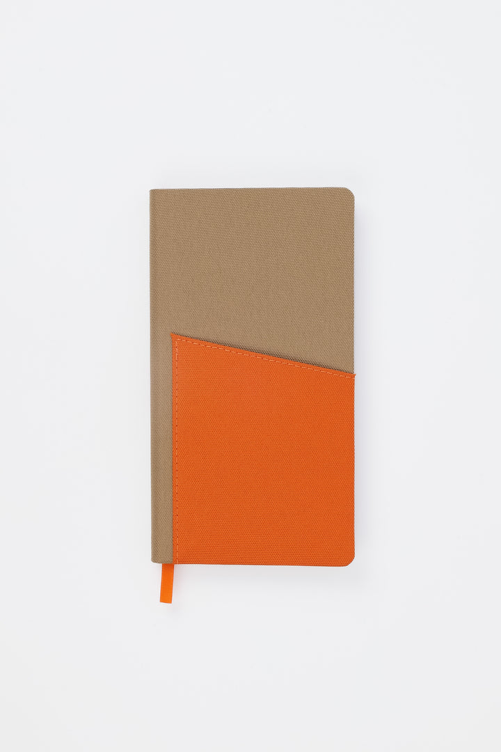 Front view of closed brown pocket notebook with orange fabric pocket

