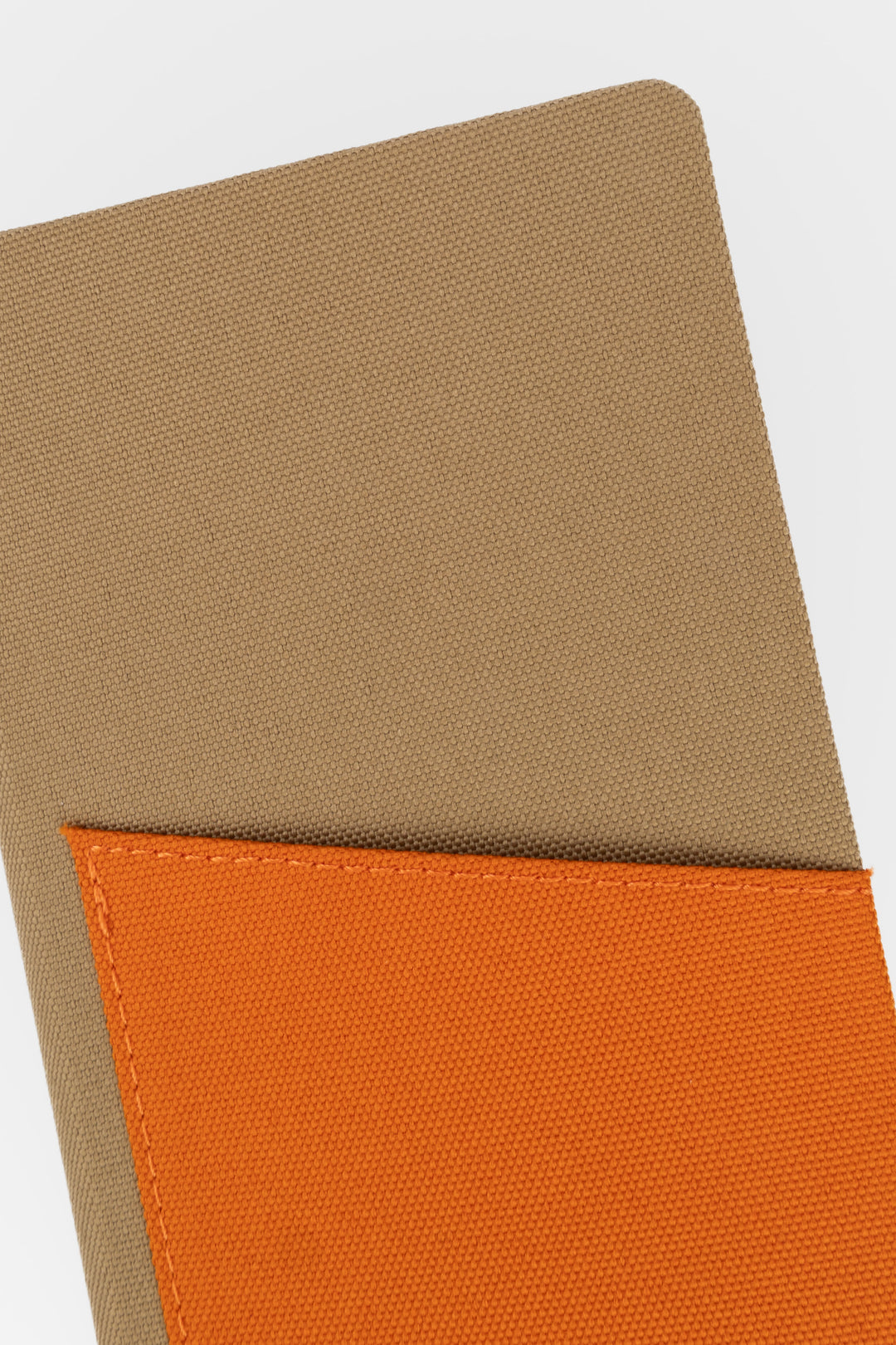 Close-up of brown fabric texture with orange fabric pocket
