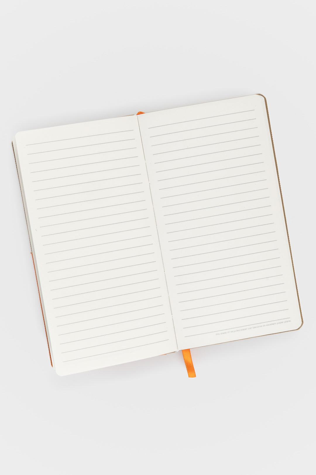 Open pocket notebook showing ruled pages and orange ribbon marker