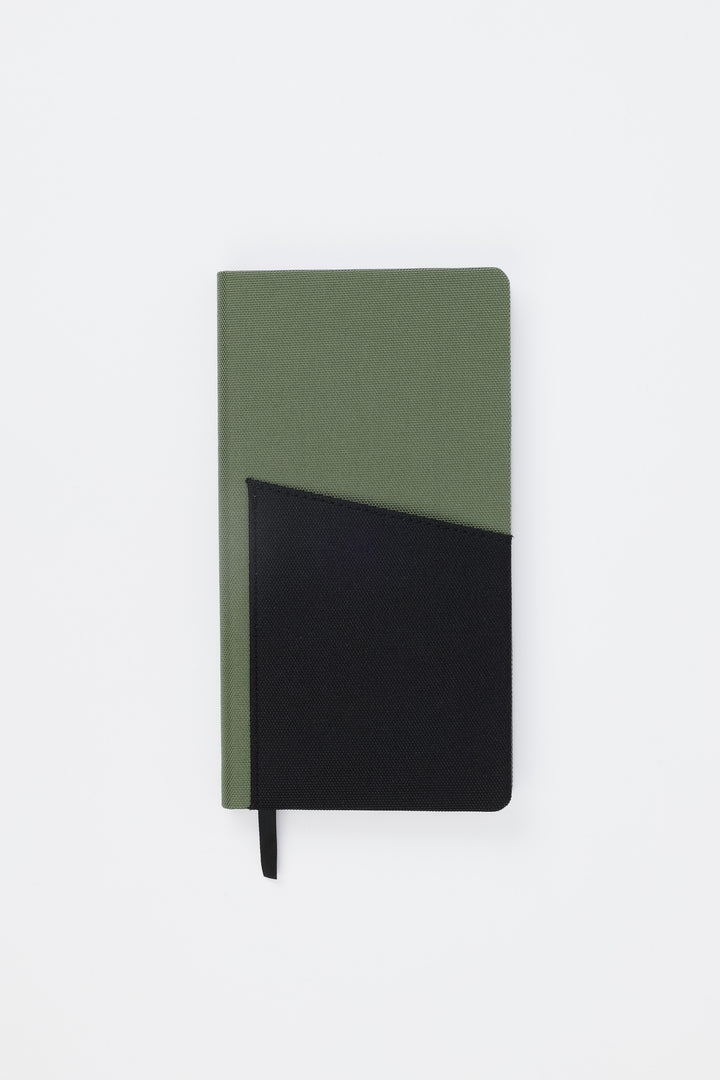 Front view of closed green pocket notebook with black fabric pocket

