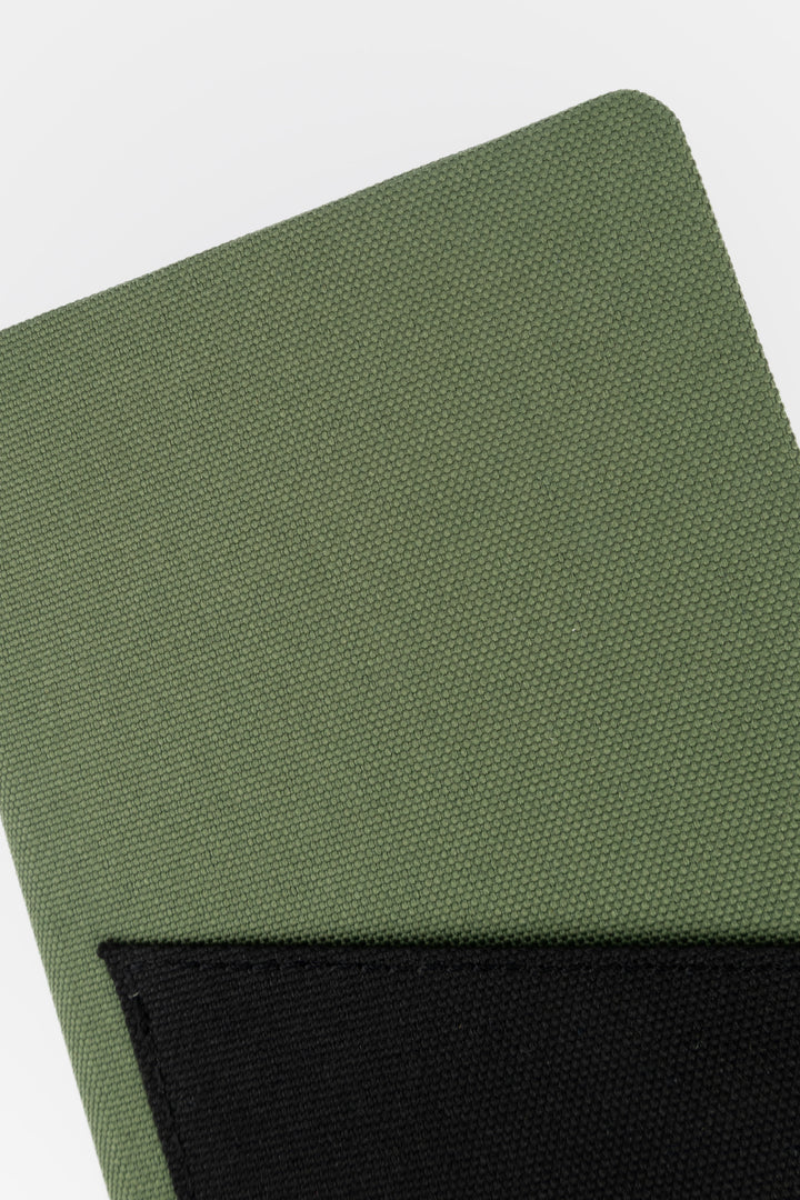 Close-up of green fabric texture on the pocket notebook cover
