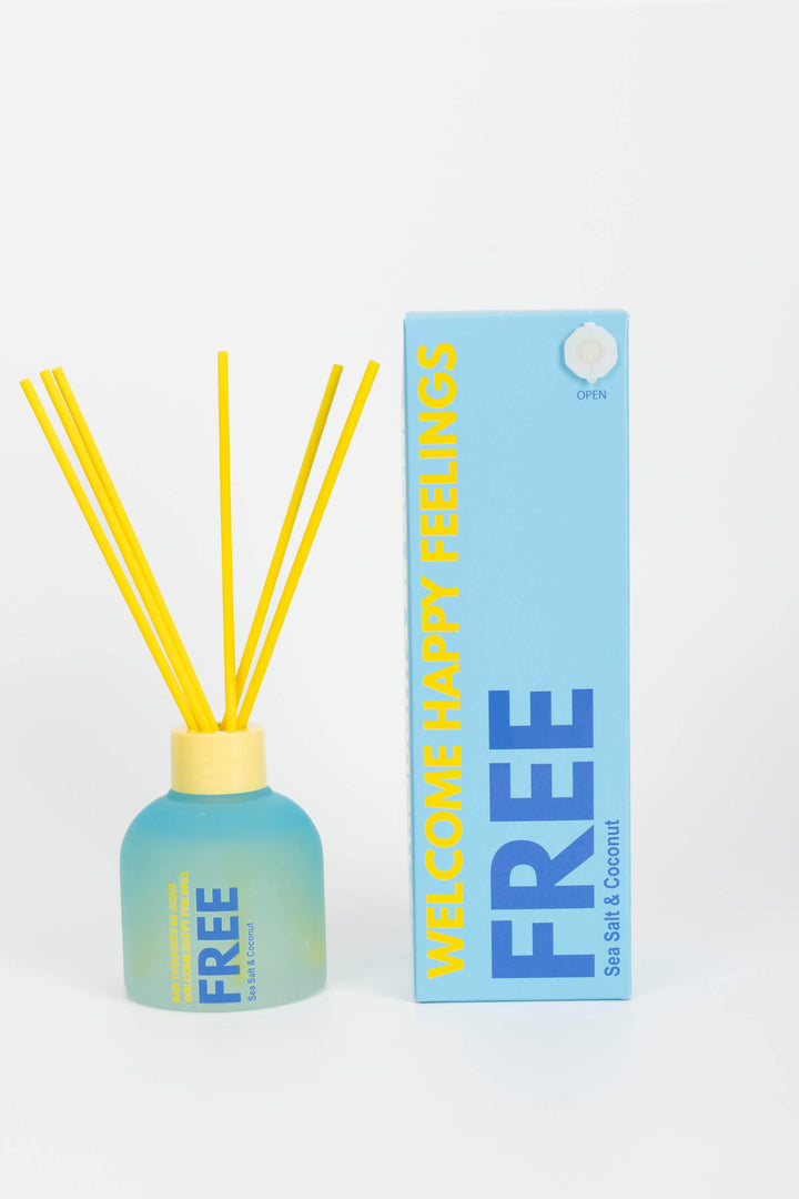 Reed diffuser with yellow sticks and a blue bottle on a white background
