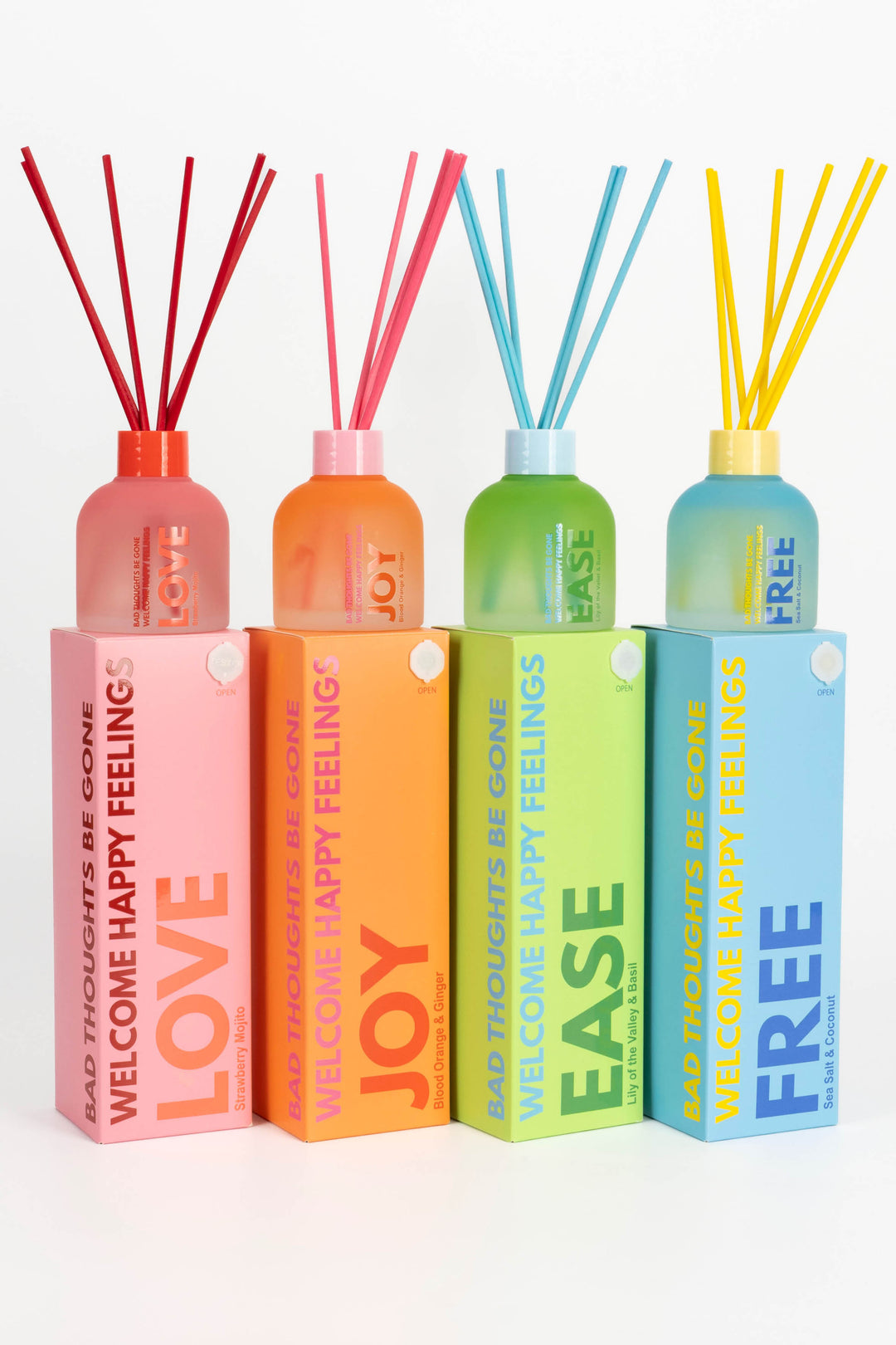 Set of four diffusers with colorful bottles and sticks on a white background