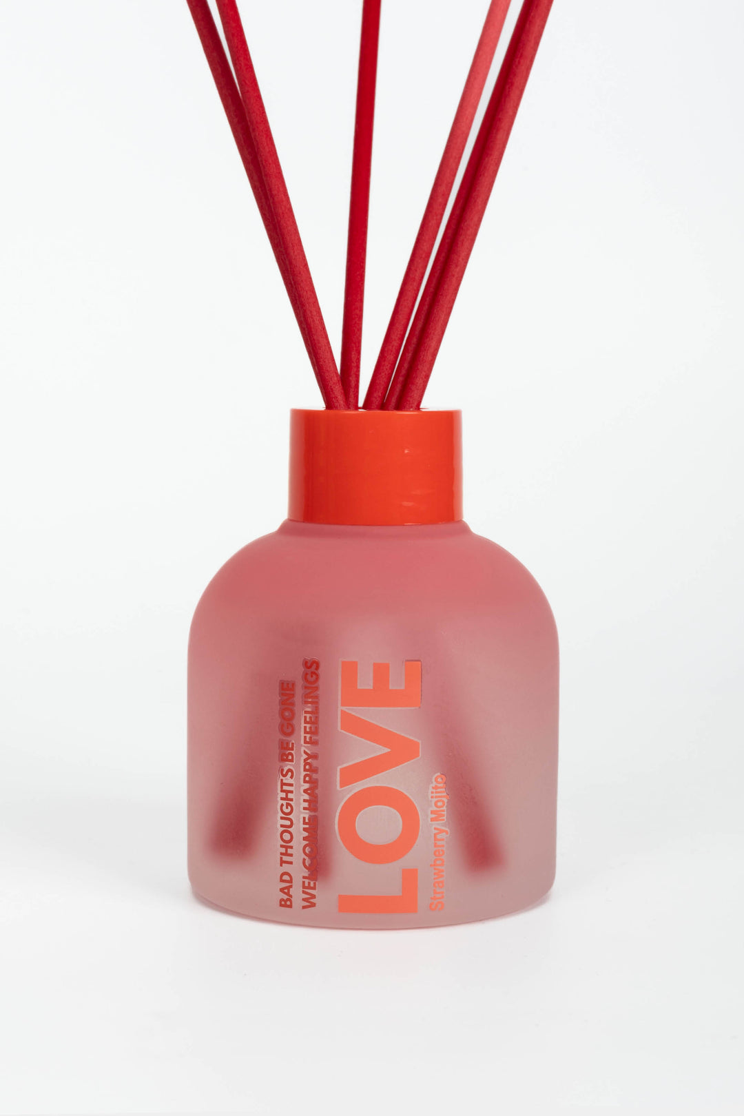 Pink diffuser bottle with red sticks on a white background