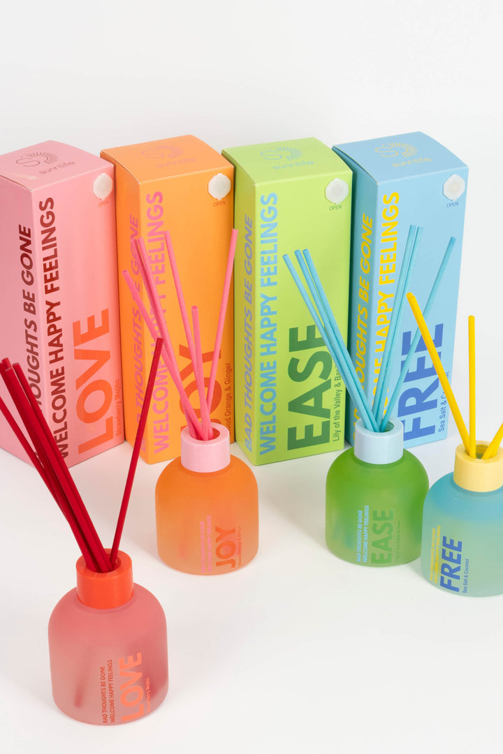 Colorful diffusers with sticks and packaging on a white background