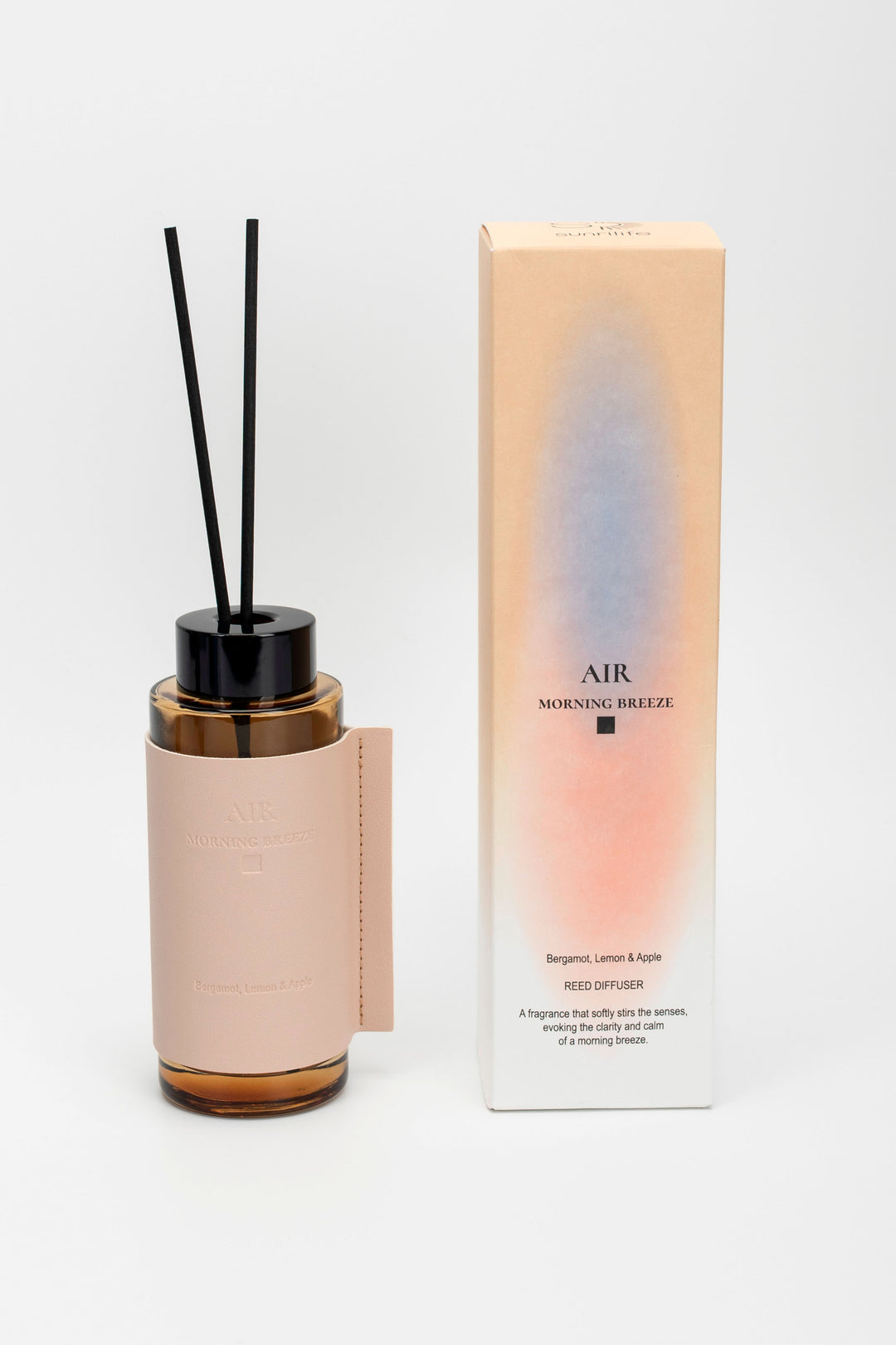 Diffuser bottle with black sticks and packaging on a white background
