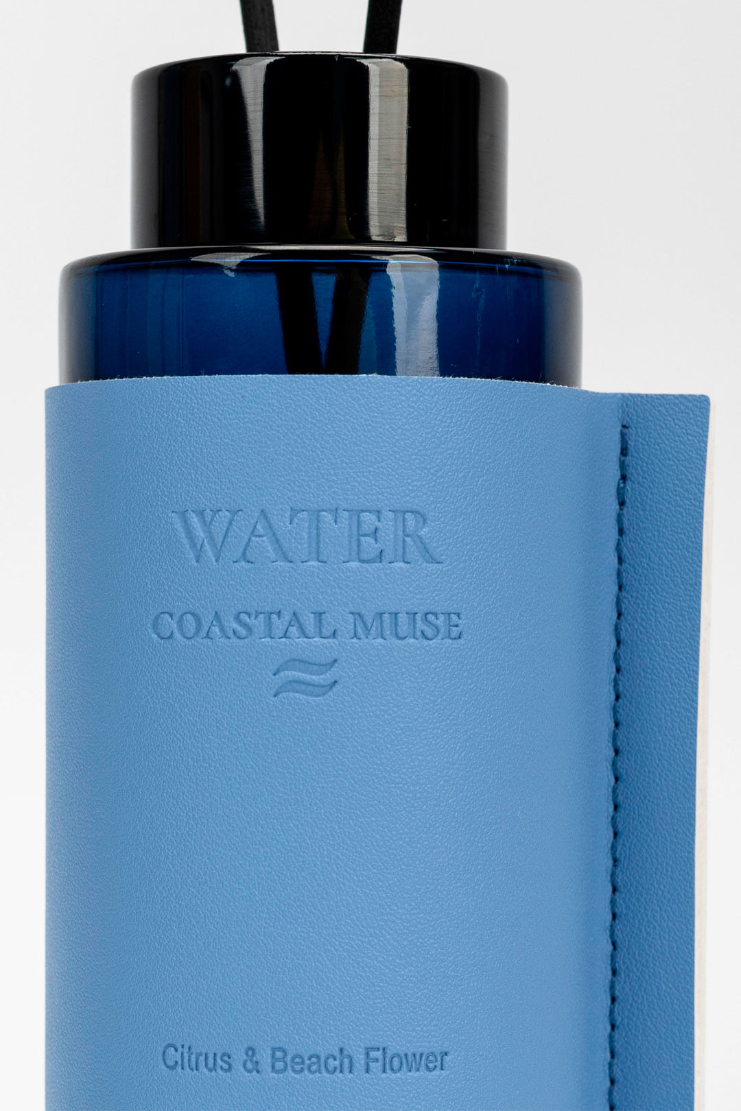 Blue diffuser bottle with black cap on a white background
