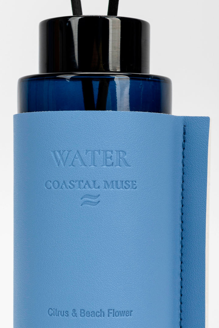 Blue diffuser bottle with black cap on a white background
