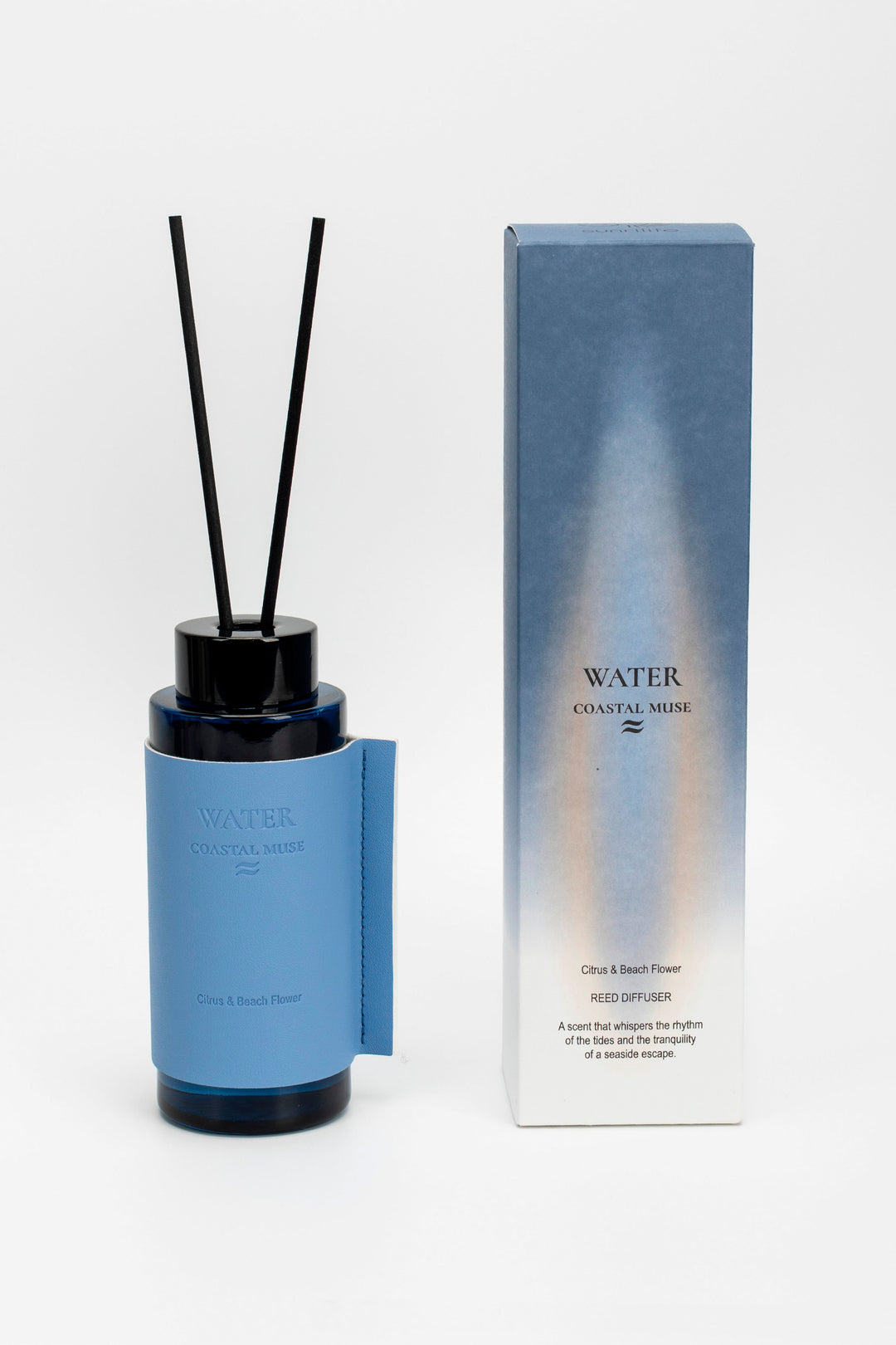 Blue diffuser bottle with black sticks and packaging on a white background