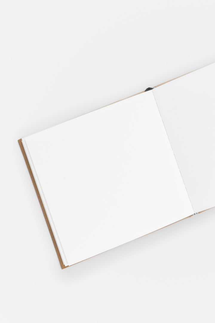 open sketchbook with brown cover on a white background