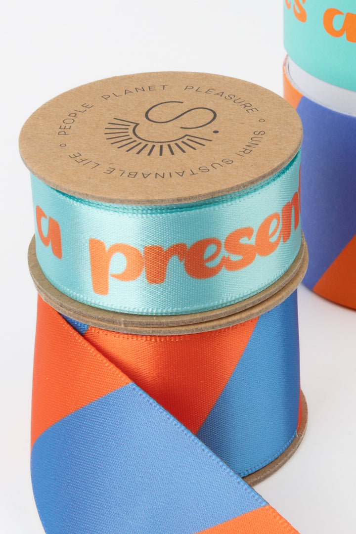 Spool of ribbon with 'People Planet Pleasure' branding on a white background
