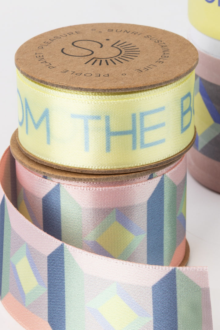 Ribbon spools with geometric pattern and text on a white background
