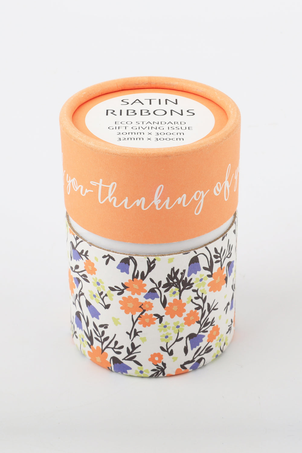 cylindrical printed paper can containing two satin ribbons size label visible on top pastel floral print around base
