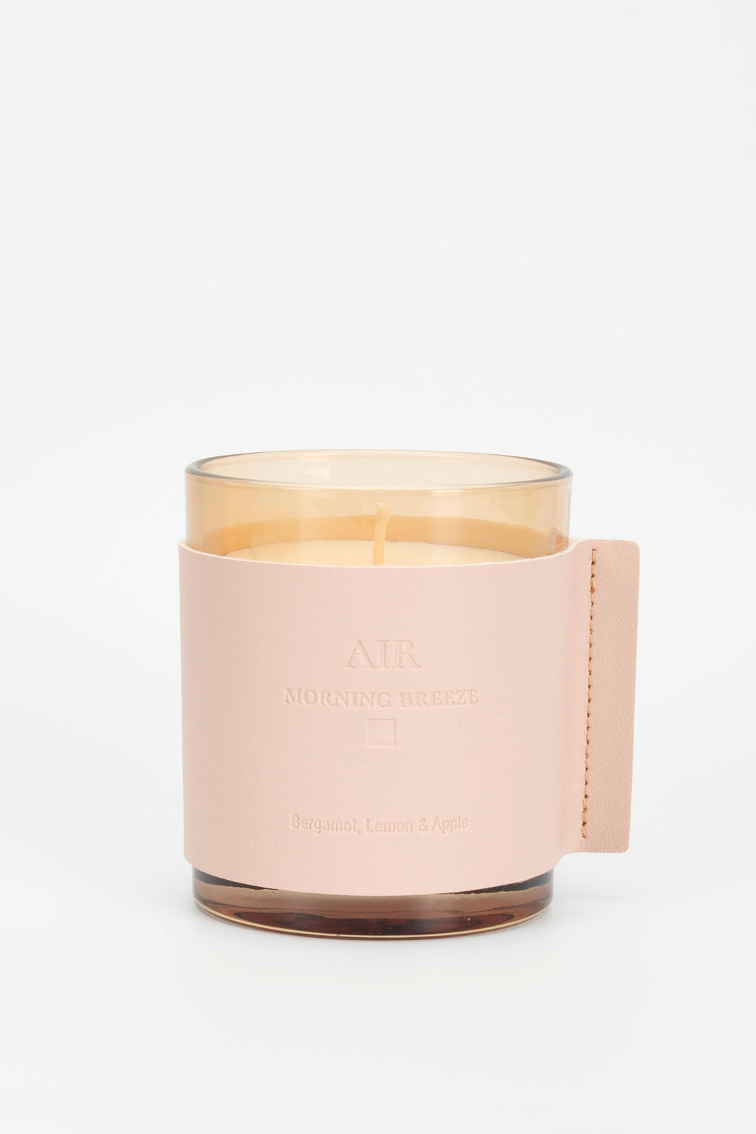 Candle with a pink holder on a white background