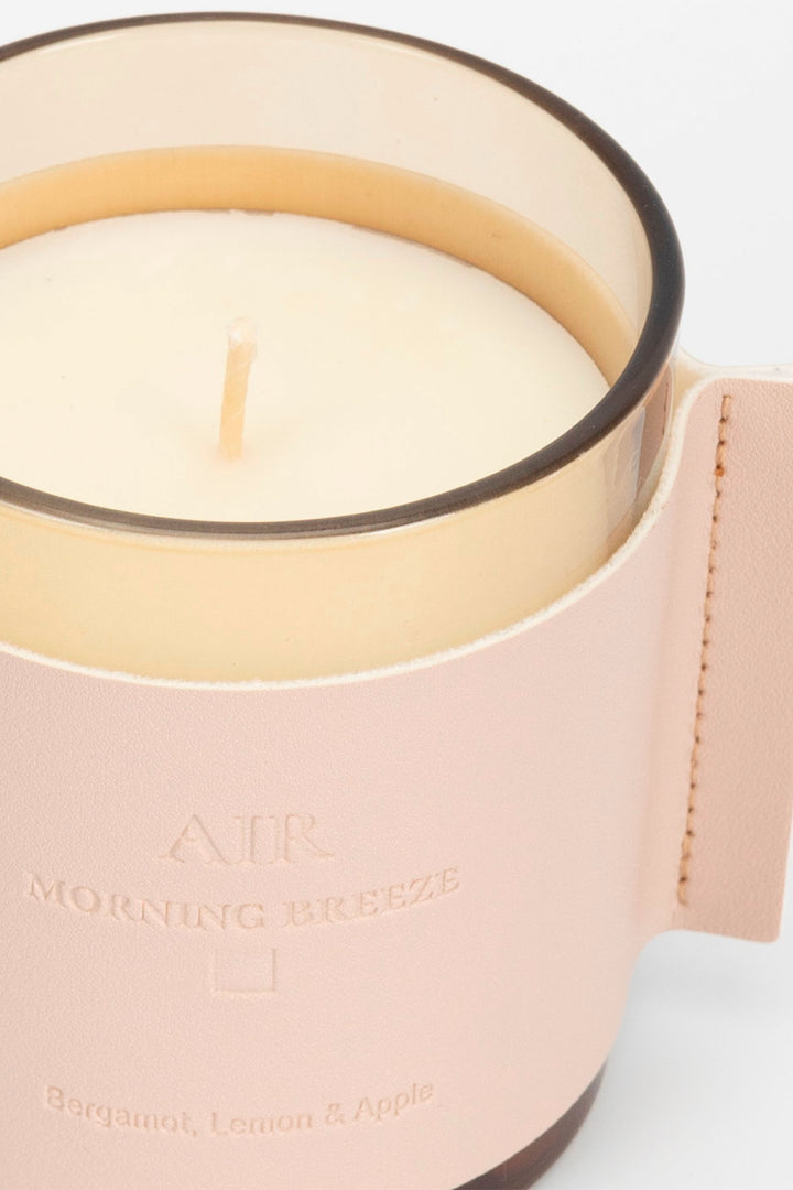 Candle in a pink holder with 'Morning Breeze' text on a light background