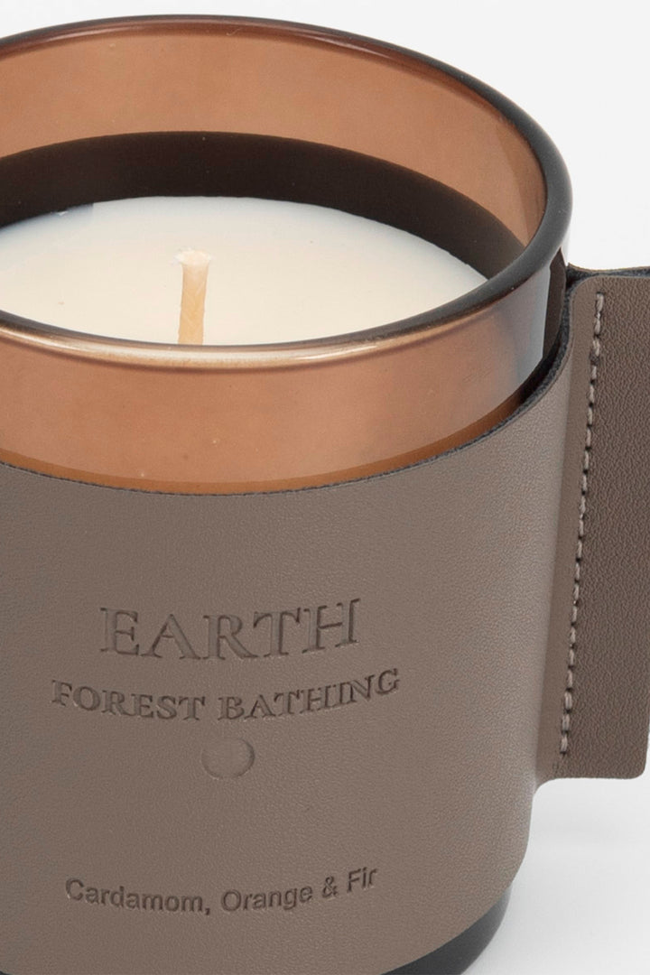 Candle in a brown container with 'Earth Forest Bathing' text on a white background