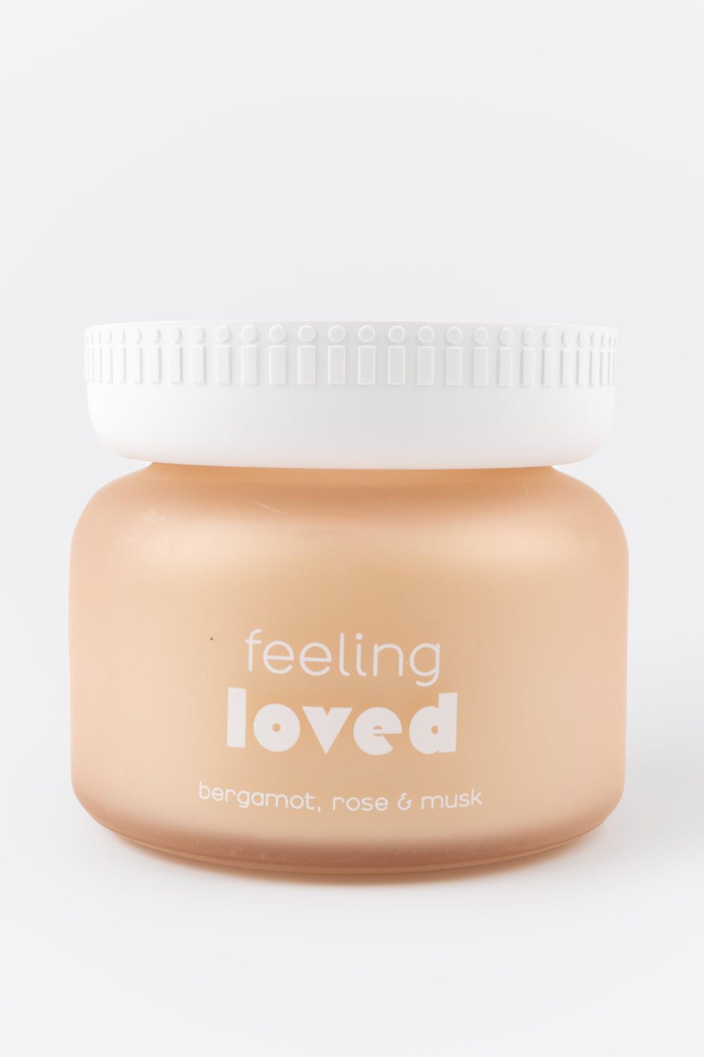 Jar with candle labeled 'feeling loved' on a white background