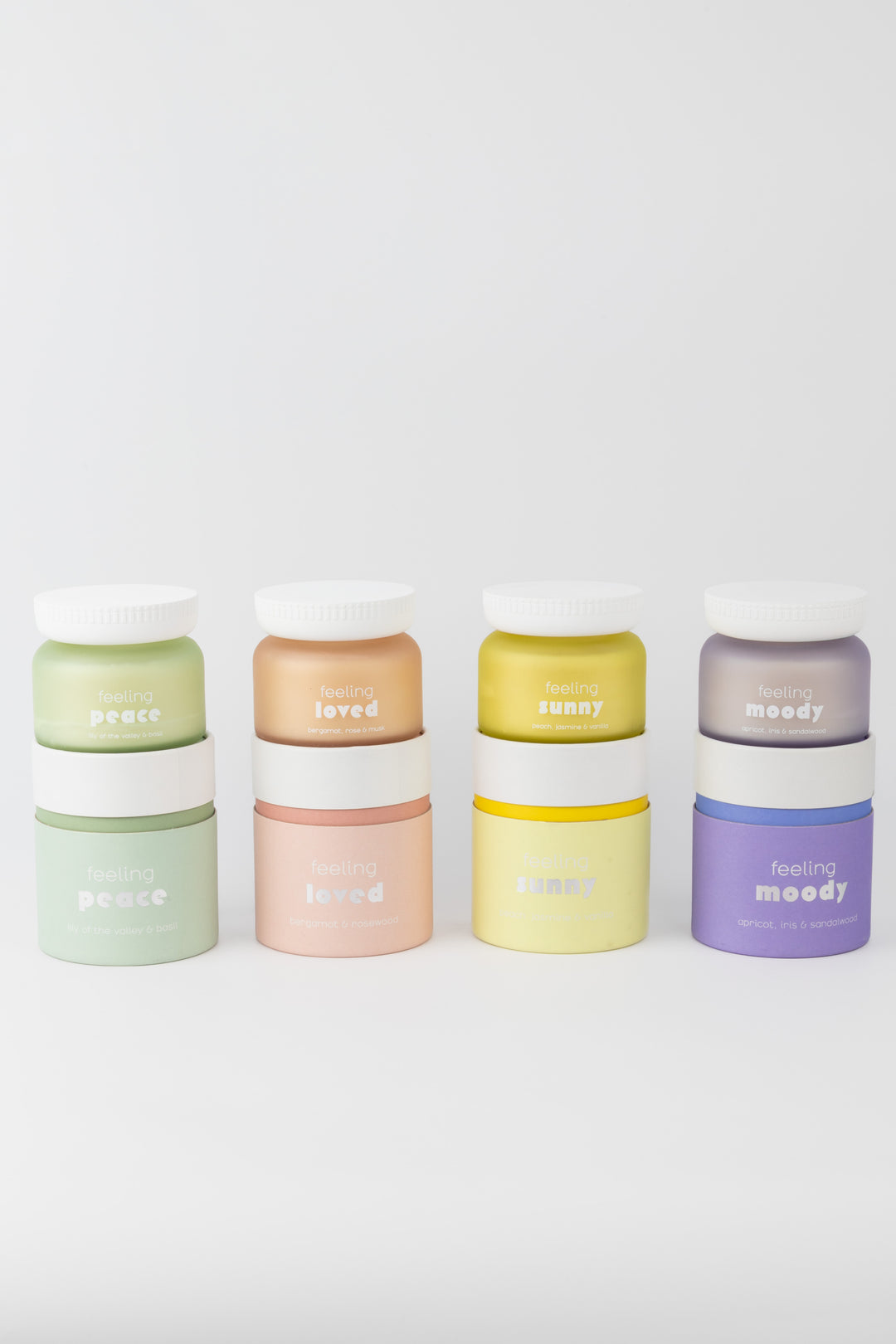 Set of colorful containers and candles with 'feeling' branding on a white background