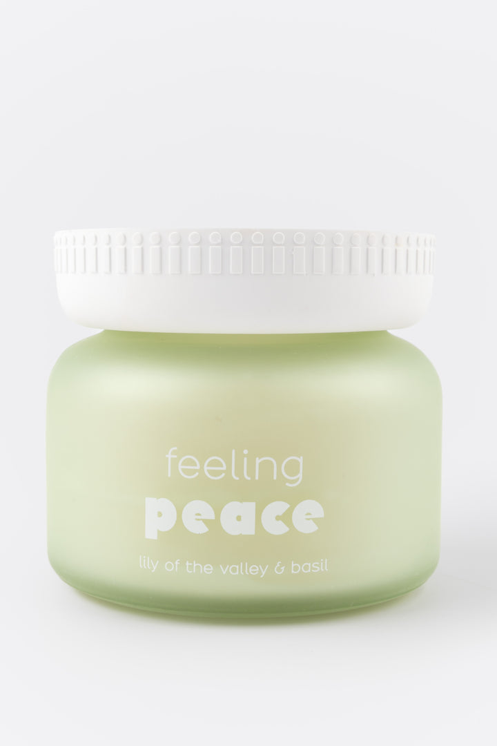 candle jar labeled 'feeling peace' on a white background