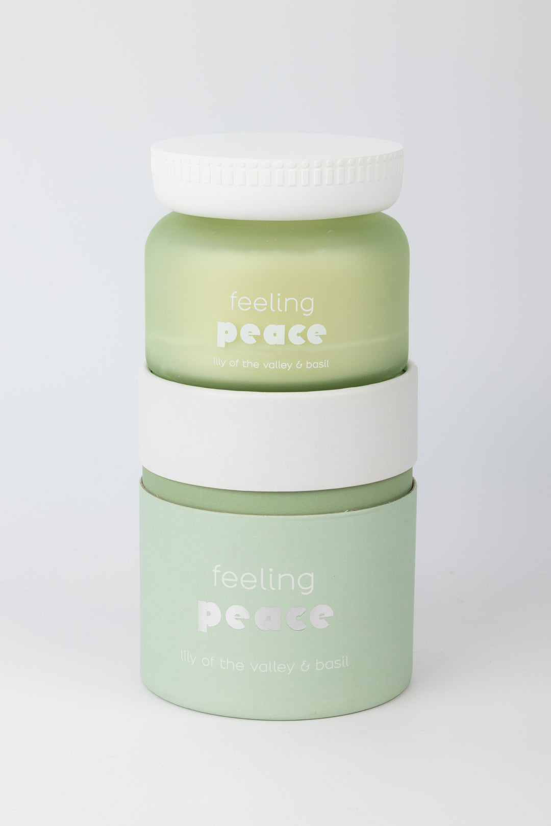 Two green containers with white lids on a white background