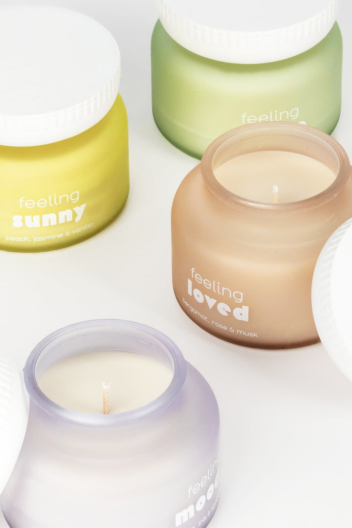 Four candles in different colors with text on a white background