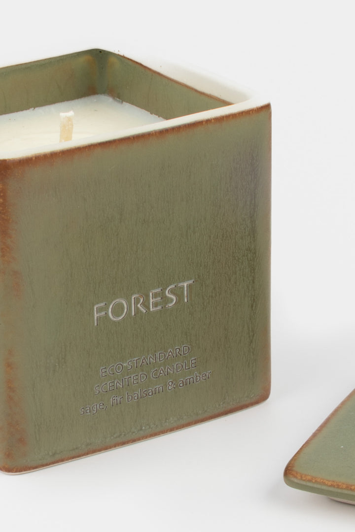 open green ceramic candle showing white wax and wick, close-up front view
