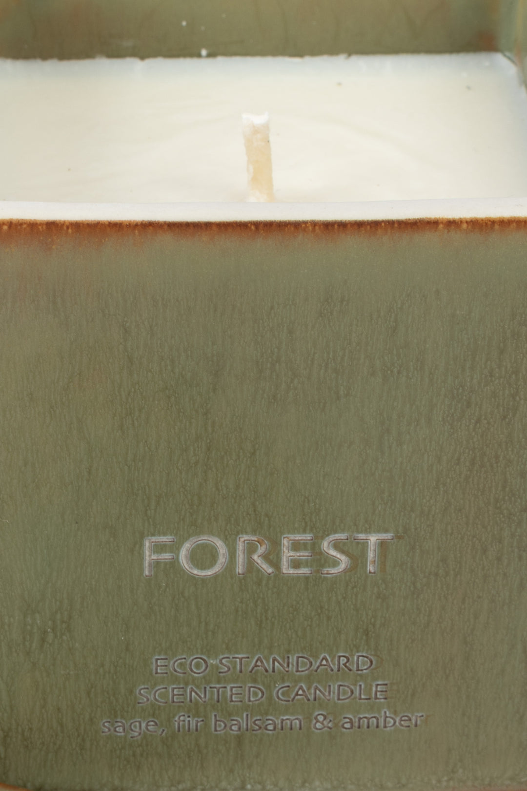 close-up of green ceramic candle rim with visible wick and wax
