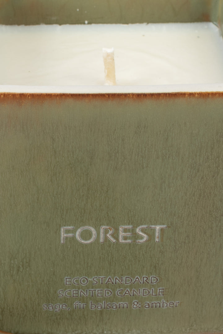 close-up of green ceramic candle rim with visible wick and wax
