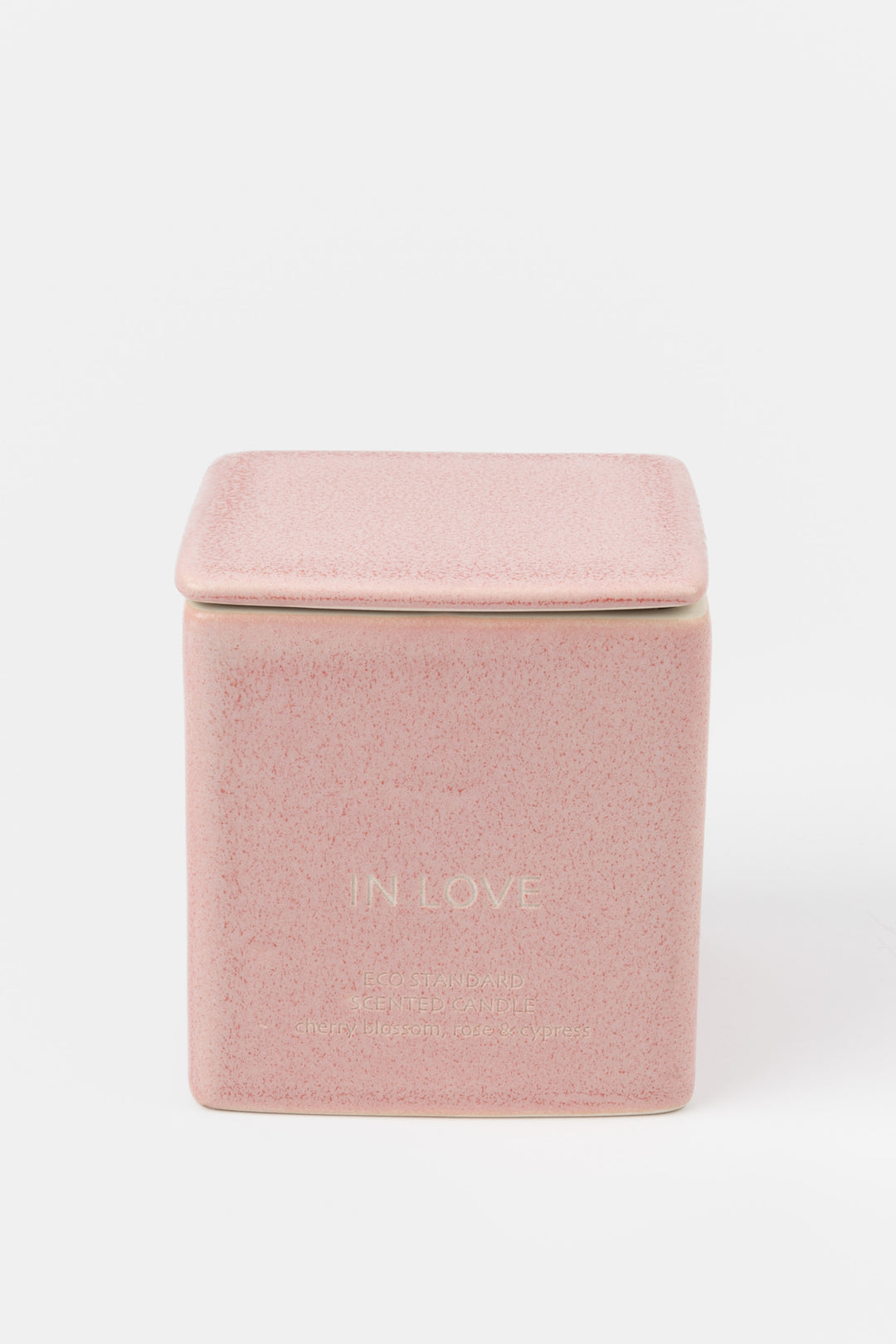 square pink ceramic candle with fitted lid, front view
