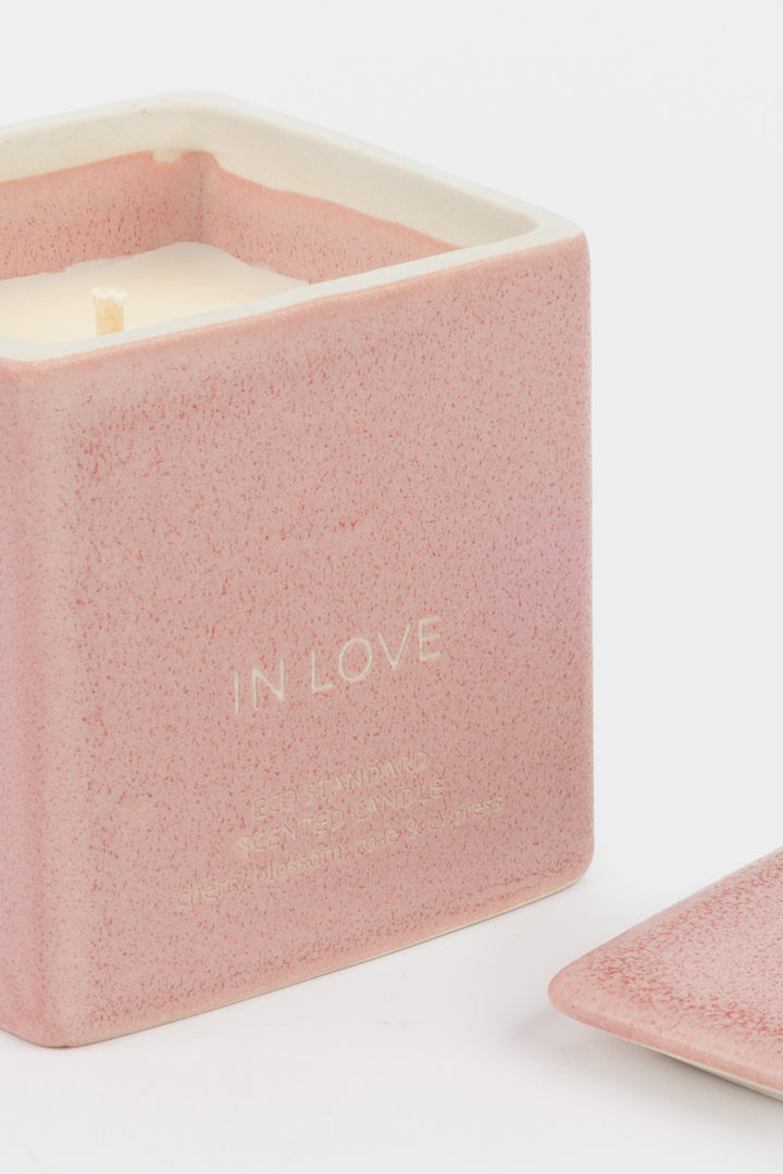 open pink ceramic candle showing white wax and wick, close-up front view

