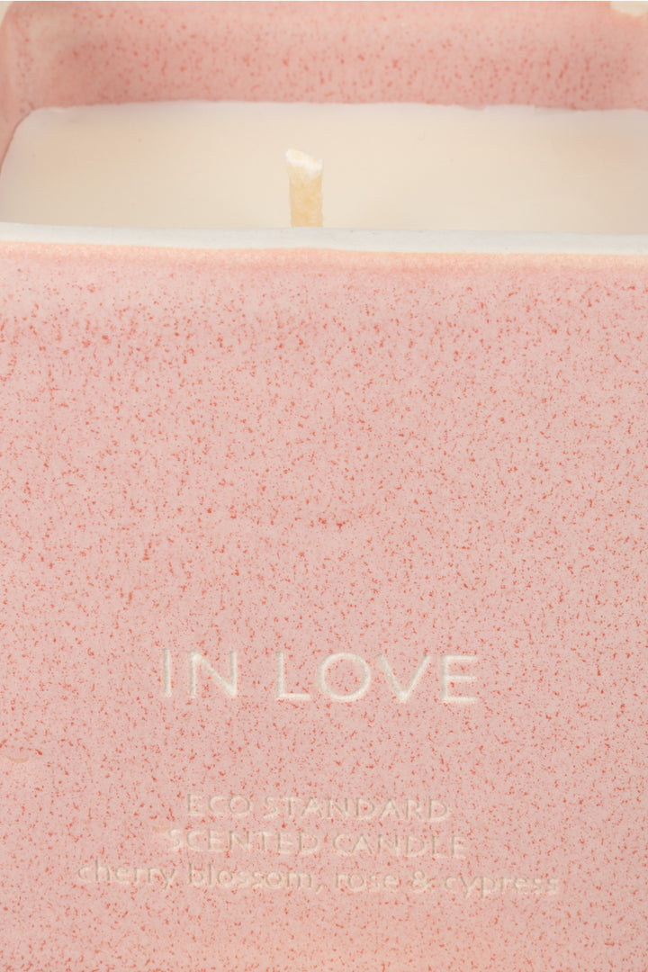 close-up of pink ceramic candle rim with visible wick and wax
