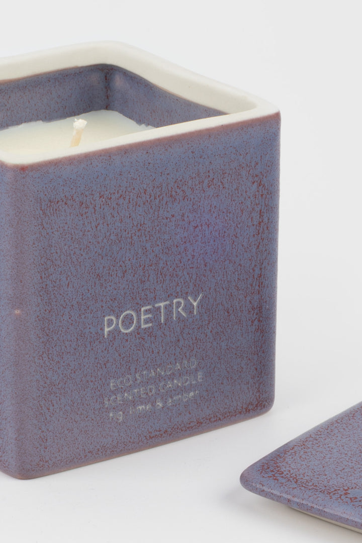 open purple ceramic candle showing white wax and wick, close-up front view
