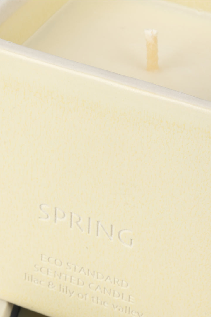 close-up of cream ceramic candle rim with visible wick and wax

