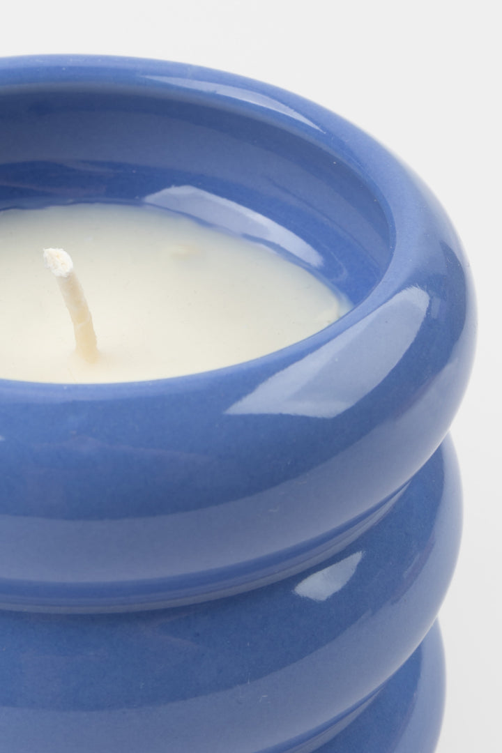 close-up of blue ceramic candle showing glossy rim and white wax
