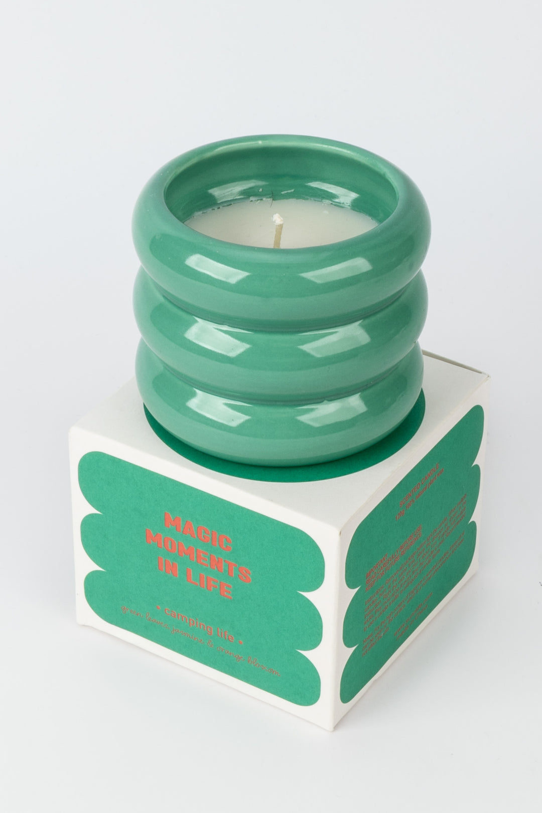 green ceramic candle placed on matching camping life packaging box
