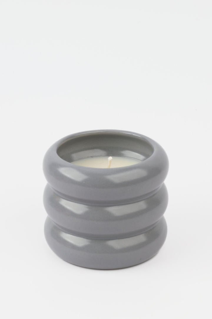grey glossy ceramic candle holder with rounded stacked shape and white wax inside
