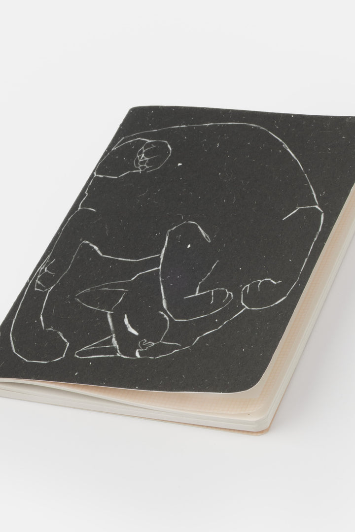 Notebook with a black cover featuring a white line drawing of a cat