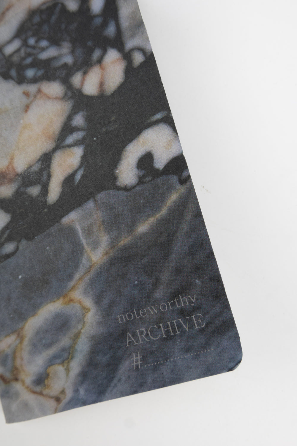 Marble-patterned detail of notebook with 'noteworthy ARCHIVE' text