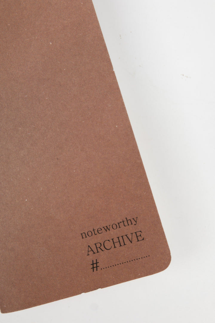 detail of brown notebook with 'noteworthy ARCHIVE' text 