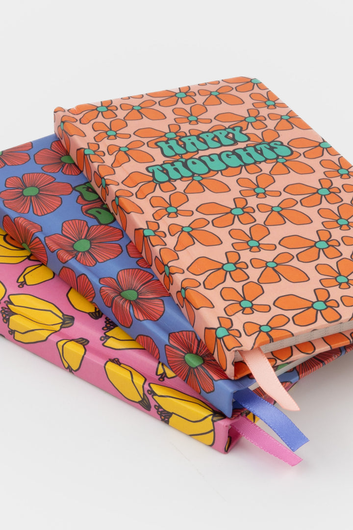 stack of three patterned journals with retro flower and fruit prints and matching ribbon markers
